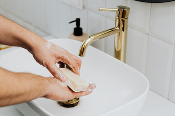 Man using a bar soap to wash his hands