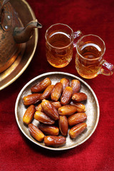 Dates fruit and Islamic Book Koran on carpet background, Islamic background in mosque