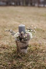 Easter composition with candles and fresh flowers on a grass background
