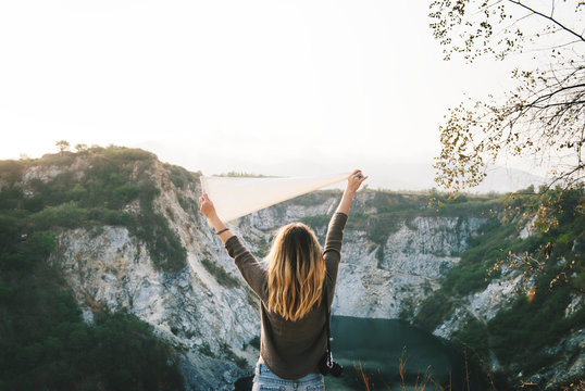 Woman Arms Raised And Holding Flag On Mountain