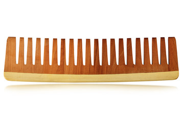 Close-up of a wooden comb for hair care isolated on a white background with reflections 