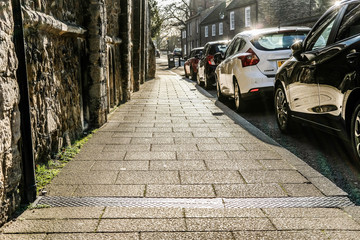 Cambridge, UK - Circa January 2020: High contrast, low level view of a typical pavement seen down a...