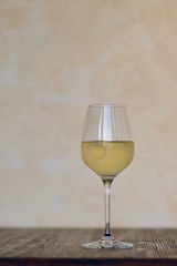 ein glas frischer weisswein steht auf einem dunklen holztisch