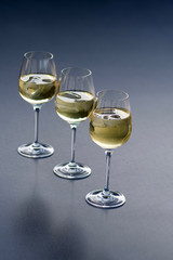 three glasses of fresh golden delicious riesling white wine in a line