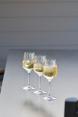three glasses of fresh golden delicious riesling white wine in a line