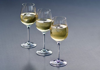 three glasses of fresh golden delicious riesling white wine in a line