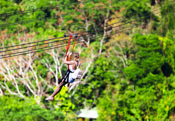 The girl descends on a bungee in the park.