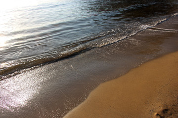 romantic sandy coast in the early sunny morning in the sun and sea tide