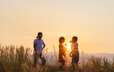 children playing on mountain at sunset background