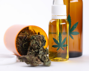 Closeup on table hemp oil and dried cannabis herb. Cannabis is an effective and safe treatment for...