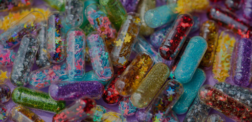 Obraz na płótnie Canvas Closeup of glittery shimmery shiny pills capsule background