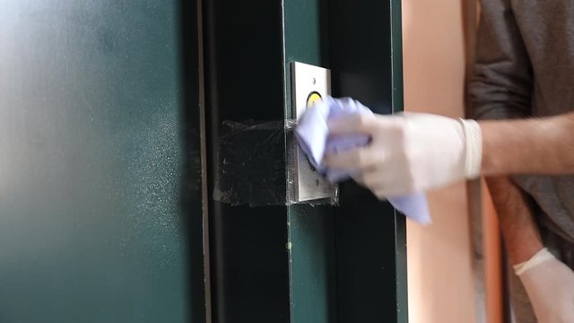 Cleaning staff Cleaned elevator switch button in hospital with alcohol spray and wipe out with clean paper. Corona Virus or bacteria infected protection from touch public object.