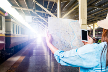 Young backpacker tourist on train platform use wi-fi internet online smartphone search travel guide information cheap deals discount promotion book bus train hotel flight after coronavirus quarantine