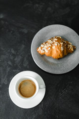 croissant and coffee on the black table