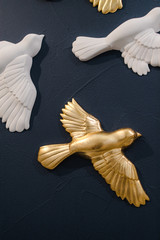 clay white and gold birds on the blue wall
