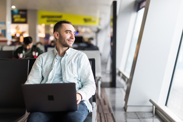 Young handsome man working on a laptop in airport