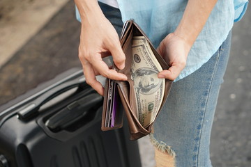 Young woman backpacker traveler hands holding wallet dollar currency money plan to saving spend...