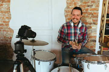 Caucasian musician playing drumms during online concert at home isolated and quarantined. Using camera, laptop, streaming, recording courses. Concept of art, support, music, hobby, education.