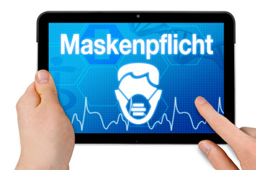 Obraz na płótnie Canvas Tablet with medical device background isolated with the german word for face mask duty - maskenpflicht
