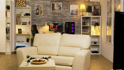 Empty room with couch in the middle and gaming computer © DC Studio