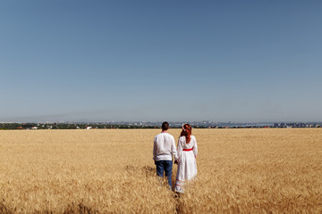 Naklejka na ściany i meble girl with a guy in a dress in wheat