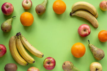 Fruits frame on a green background top view