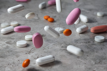 Pharmacy background on a dark table. Levitation pills. Tablets on a dark background which falling down. Pills. Medicine and healthy. Close up of capsules.