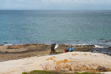 View over Boulders Beach with a couple siting on a rock