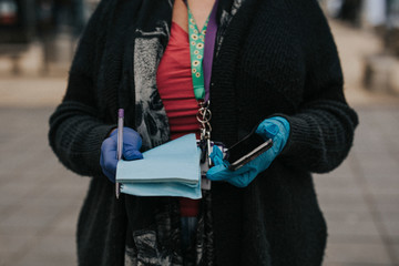 Woman wearing protective latex gloves and holding a phone. BRISTOL, UK, March 30, 2020