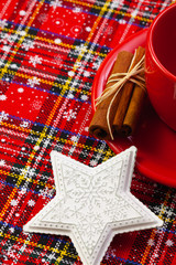 Photo of red cup of coffee, cinnamon and placemats.