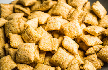 Wholegrain pillow cereals in bowl on the rustic background. Selective focus. Shallow depth of field.