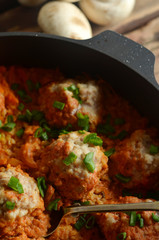 Meatballs with groats in tomato sauce in a pan