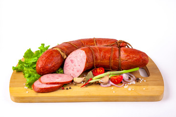 boiled sausage with vegetables lies on a cutting board on a white background