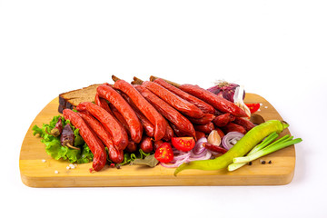 
sausage on a cutting board with herbs and vegetables white background