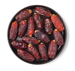 Dates on a black plate, isolated on white, from above