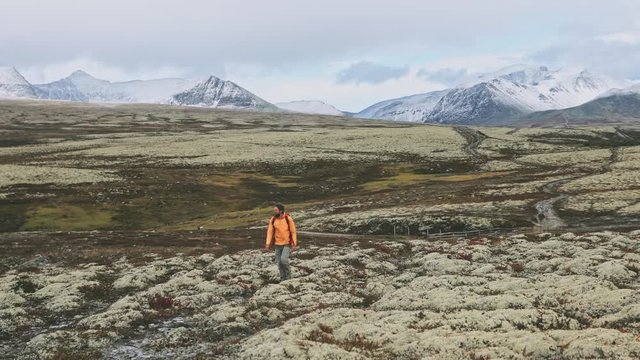Man backpacking in mountains travel outdoor expedition hike in Norway adventure trip active healthy lifestyle vacation Rondane park scandinavian landscape autumn season