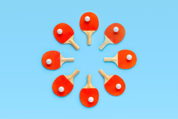 Red rackets for table tennis with white balls on blue background. Ping pong sports equipment in minimal style. Flat lay, top view, copy space