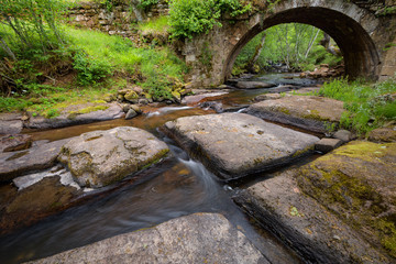 Bella vista de un viejo puente de piedra en el río Camesa, cerca de la población de Valberzoso,...