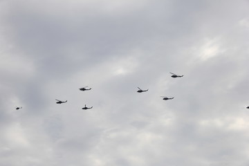 曇天に飛ぶ複数のヘリコプター