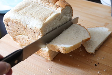white sliced loaf of fresh bread, knife to cut into portions