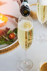 Pouring prosecco sparkling wine in a glass on sunday brunch © Diana Vyshniakova