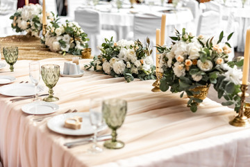 White wedding decoration in restaurant. Luxury wedding arrangement. Wedding banquet decoration. Tables in restaurant decorated with beautiful white peonies and roses