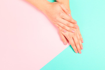female  manicure. Beautiful young woman's hands on pastel   background - Image