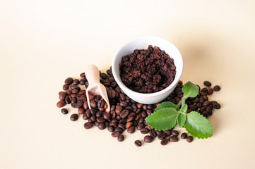 Fototapeta na wymiar Cofee beans, sugar scrub in ceramic bowl, mint leaves, wooden scoop. Natural home made cosmetics.