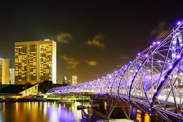 Verlichte Helix-brug over rivier in de stad & 39 s nachts