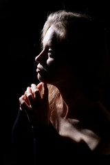 Portrait of a girl illuminated by the contour light of a flash on a black background