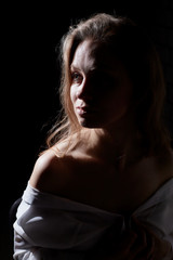 Obraz premium Portret dziewczynki oświetlonej konturowym światłem lampy błyskowej na czarnym tle