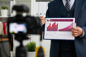 Male in suit and tie show stats graph pad making promo videoblog or photo session in office camcorder to tripod closeup. Vlogger selfie sale solution or finance advisor management information © H_Ko