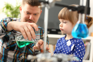 Man and little girl play with colourful liquids portrait. Young team clean research equipment colour reagent food additions flavor activity flavour concept