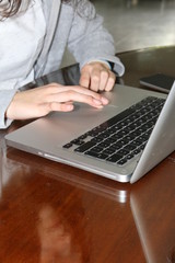 young woman hands typing on laptop